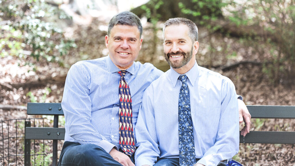 two men on a bench in shirts and ties