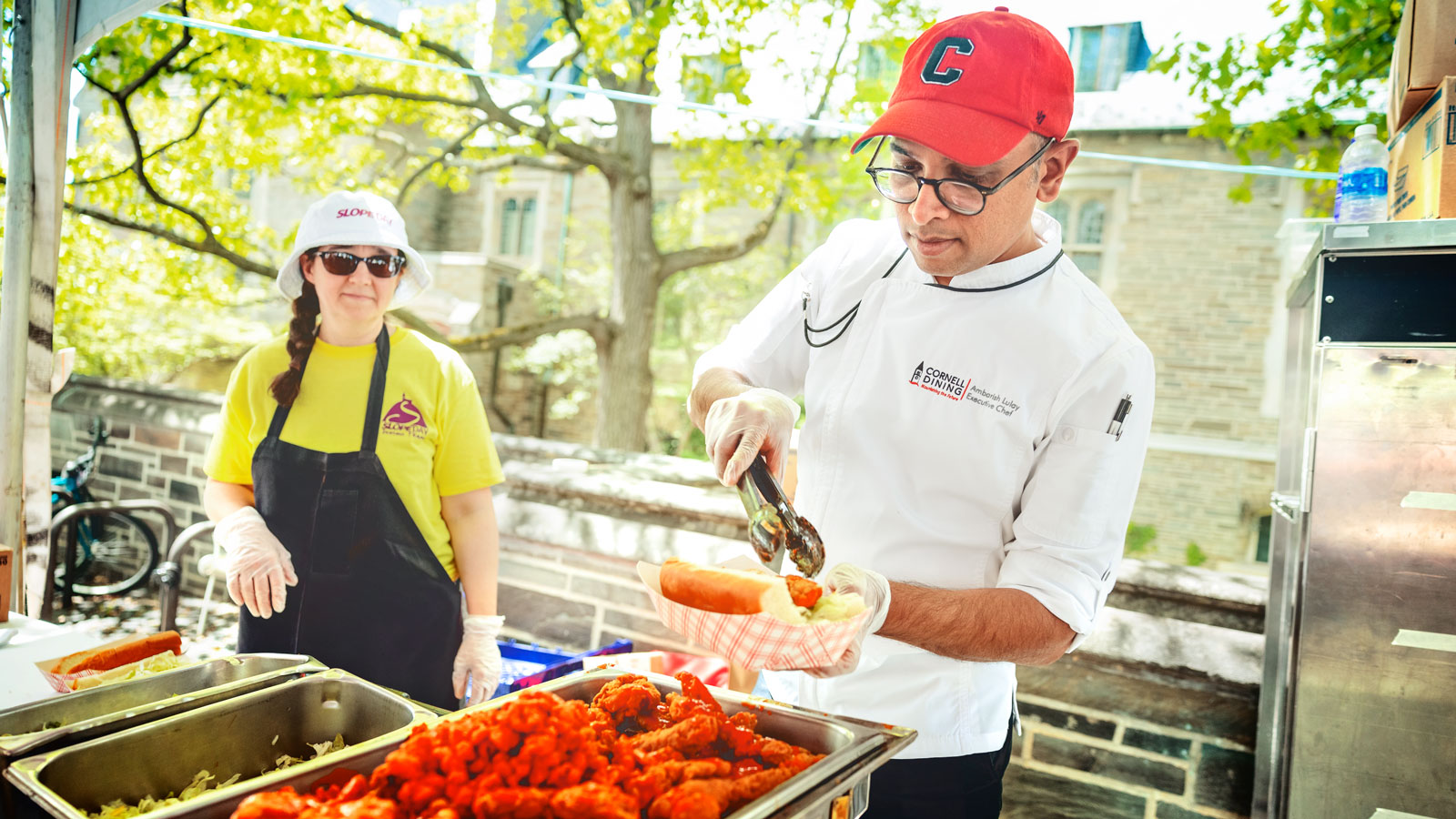 A Cornell Dining staffer serves food on Ho Plaza during Slope Fest 2024
