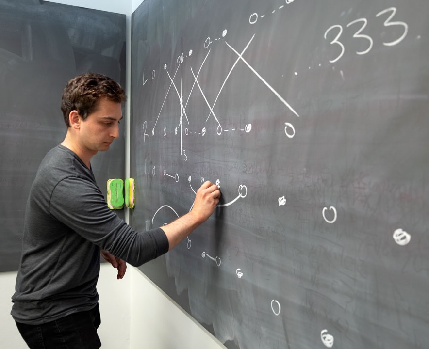 Jonah Botvinick-Greenhouse, math PhD student, writes out "siteswap" notation in Malott Hall.
