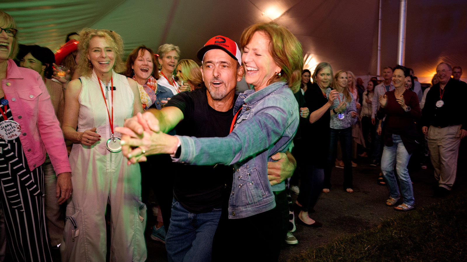 Reunion attendees watch a couple dance in the tents on the Arts Quad during Reunion 2024