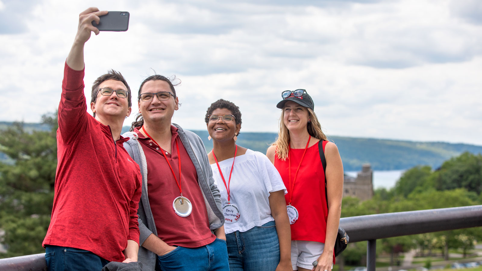 Attendees take a selfie atop the Slope with Cayuga Lake in the background during Cornell Reunion 2024