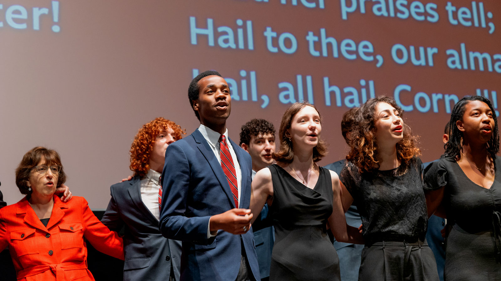 Members of student a cappella singing groups After Eight and The Hangovers lead the Alma Mater at the close of the State of the University Address in Bailey Hall during Reunion 2024