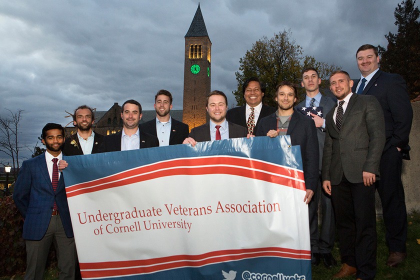 Members of the Undergraduate Veterans Association hold a banner on Ho Plaza..