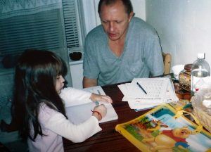Karina’s grandfather, Vasyl Rudeychuk, helping her with her math homework