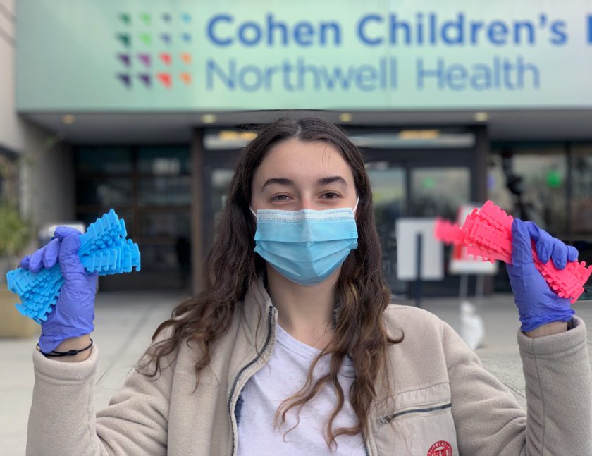 Karina holding ear savers (a type of PPE that relieves pressure from the ears when wearing a surgical mask) that she 3D printed and donated to the Cohen Children’s Hospital.