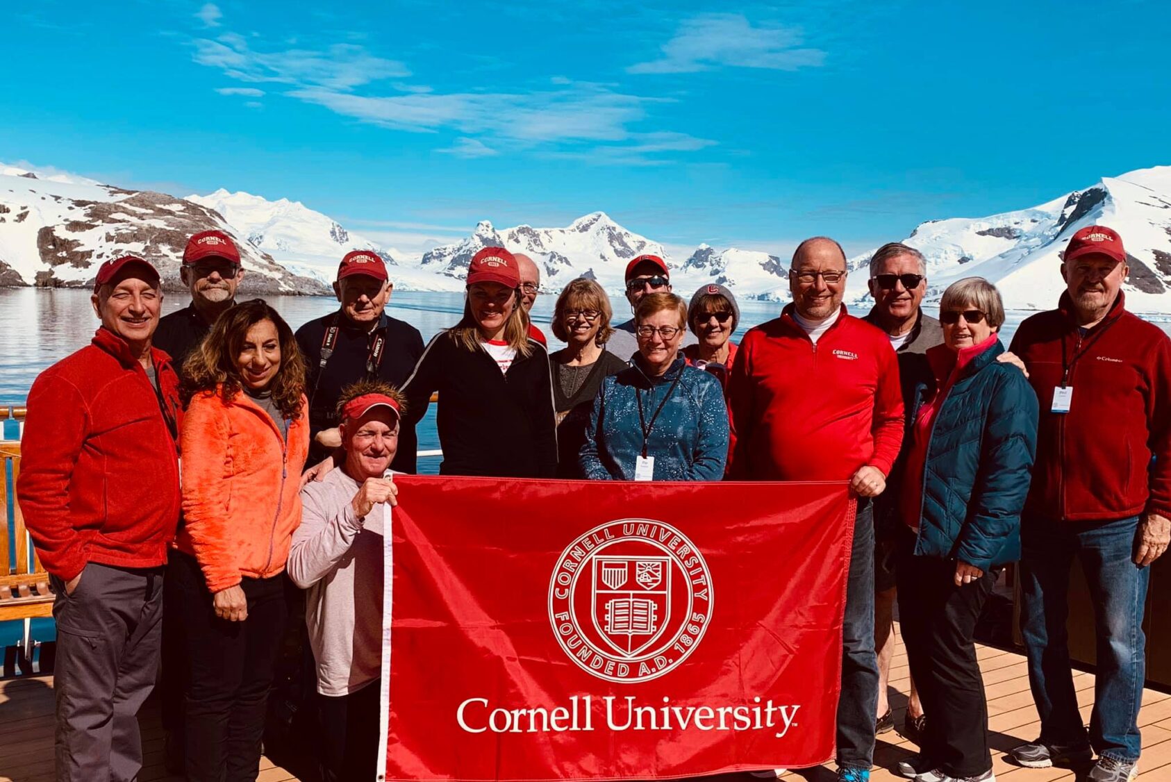 Alumni holding a Cornell pennant up in Antarctica