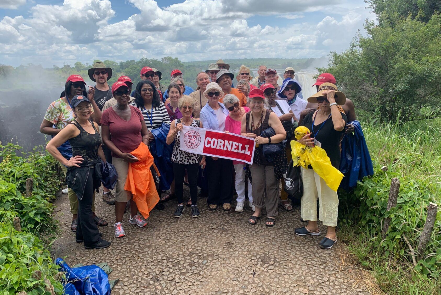 Alumni holding up a Cornell pennant in Africa