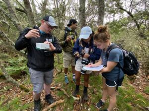 Kris Hendrickson ’24, Hannah Araújo ’25, Kathryn Fligstein ’24, and Juan de Dios Morales (photographer) prepare a SwiftOne Recorder to record the songs of Hawaiian birds.